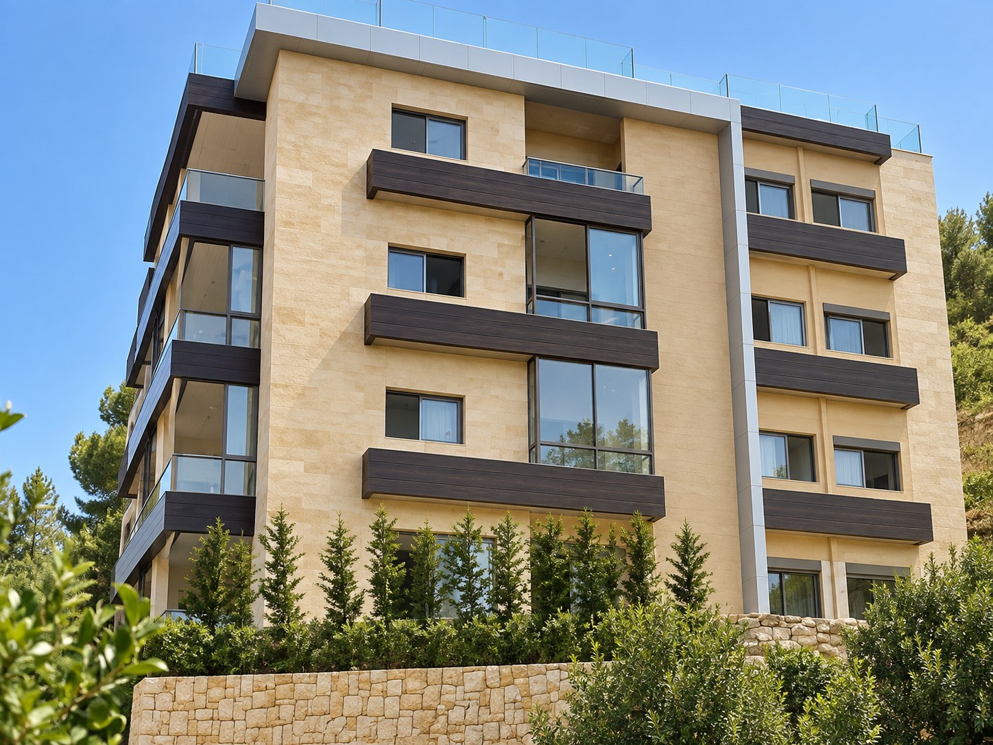 Adma Residence corner seen from below: stone facade, dark timber balcony bands and a glass-railed roof terrace
